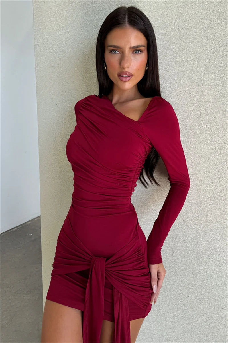 Woman wearing a burgundy dress against a neutral wall