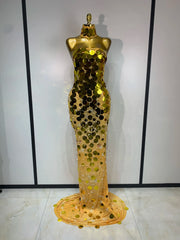 Mannequin wearing a gold sequin evening gown against a white background