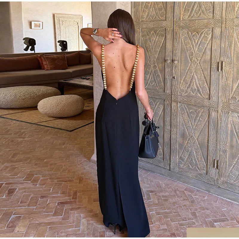 Back view of a sleeveless black maxi dress with white polka dots and a deep open back.