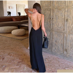 Back view of a sleeveless black maxi dress with white polka dots and a deep open back.