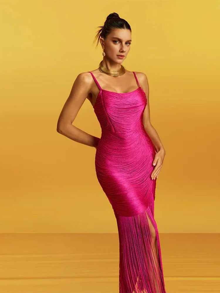 Woman wearing a pink dress with fringe details against a yellow background