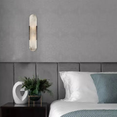 A sleek marble wall sconce with a warm LED light, illuminating a modern bedroom with a minimalist aesthetic. b