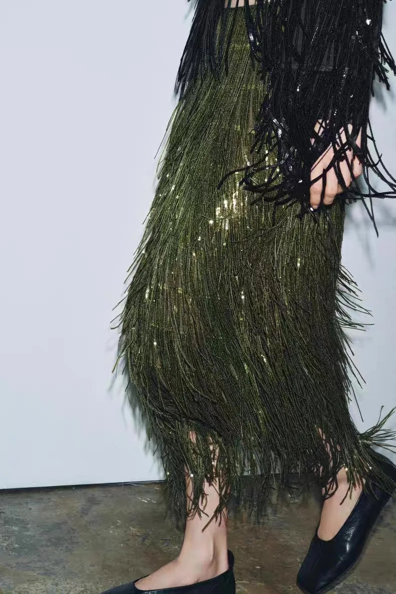 Green fringe skirt with black top on a plain background