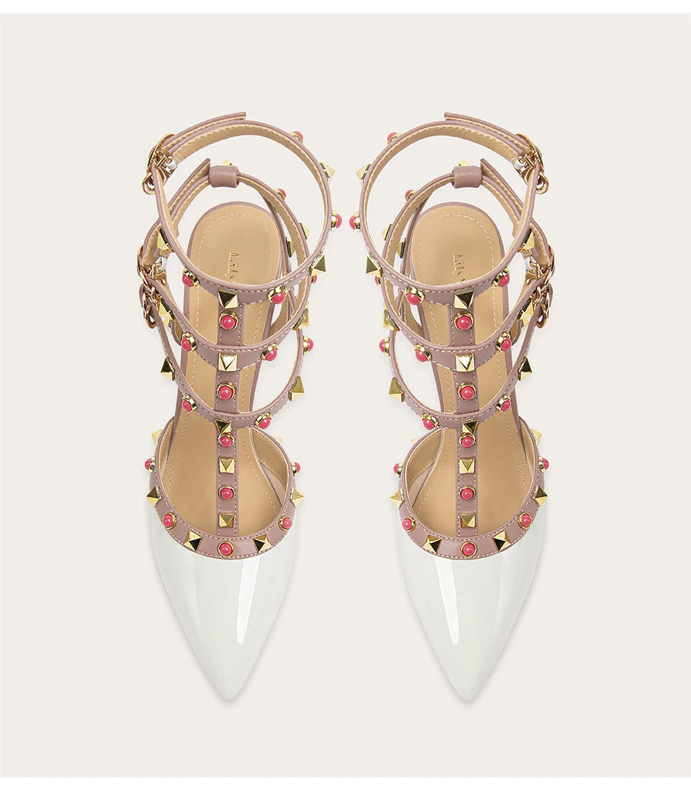 Pair of studded high-heeled shoes with clear soles on a white background