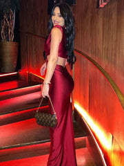 Woman in a red dress holding a handbag on a staircase with warm lighting