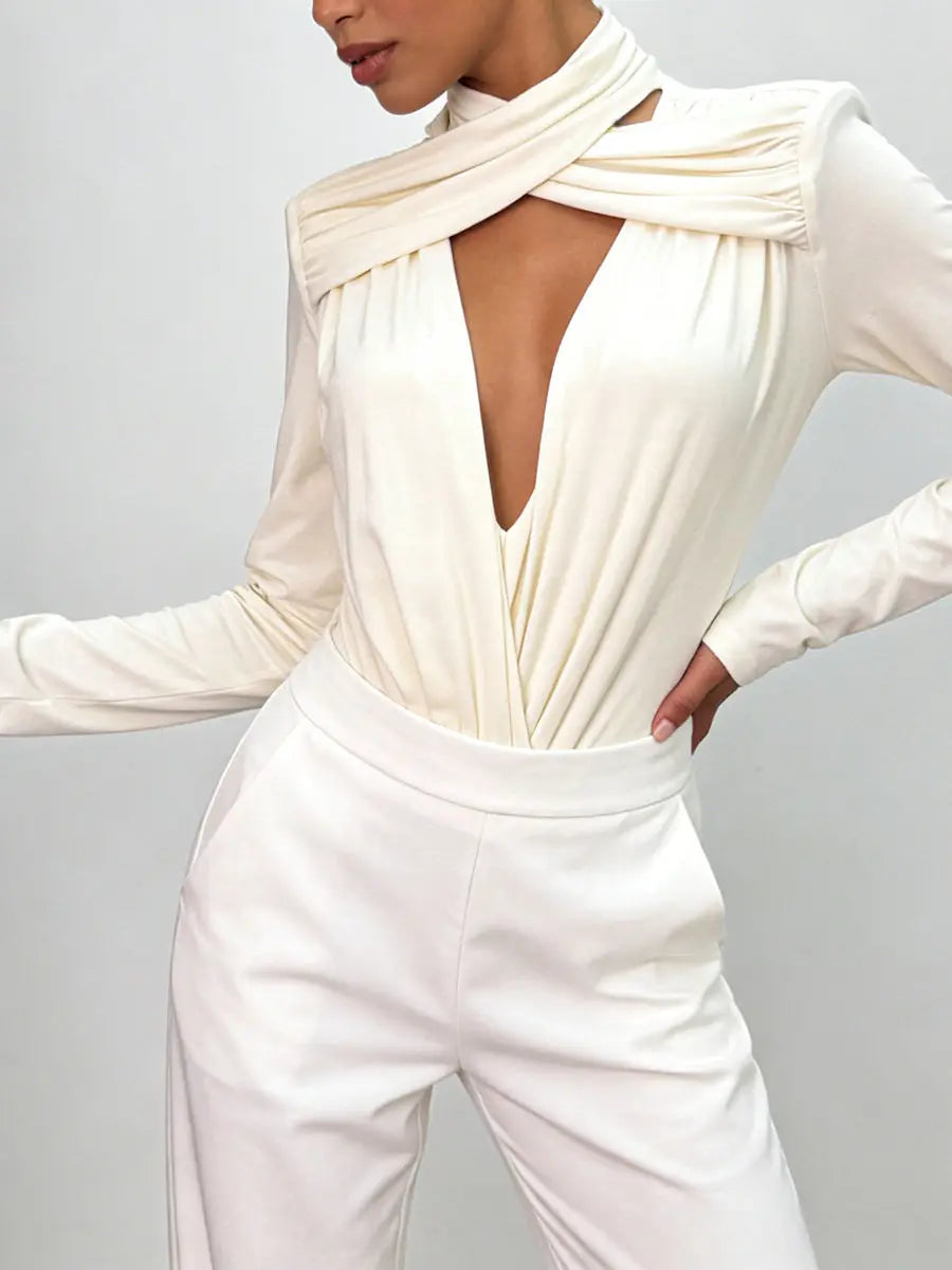 An apricot long-sleeve bodysuit with a deep neckline on a grey background