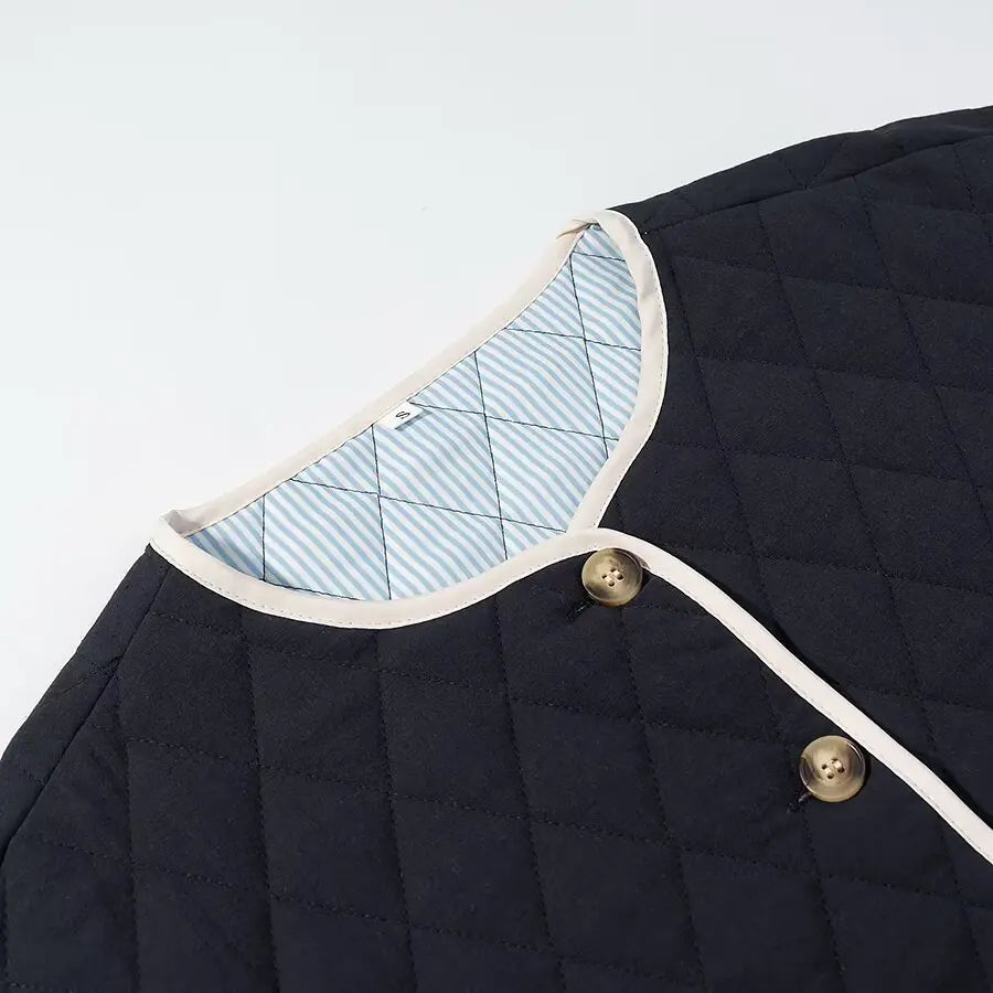 Navy quilted jacket with white trim and gold buttons on a light gray background