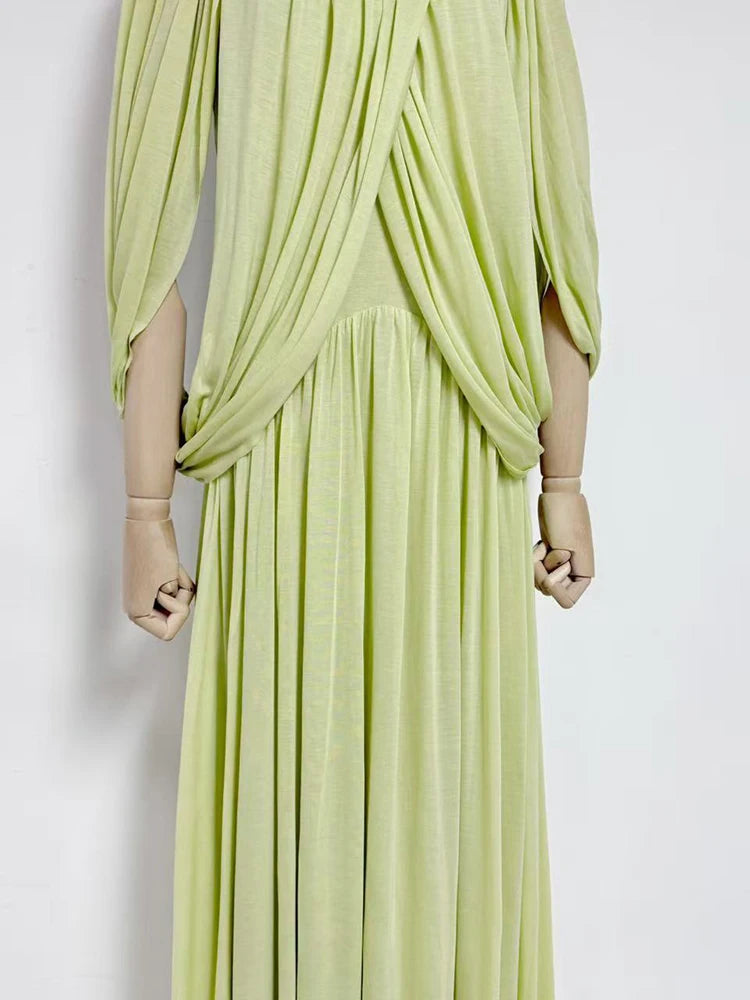 Light green draped dress on a mannequin against a white background