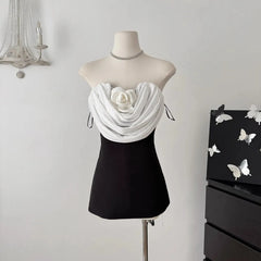 Black & White strapless mini dress on mannequin with sculpted rose applique and draped front