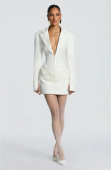 Woman wearing a white blazer and skirt set on a plain background