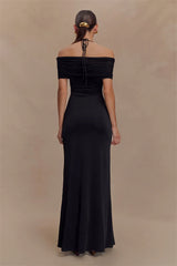 Black off-shoulder gown on a model against a beige background