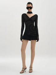 Model wearing a black long-sleeve dress with a V-neckline on a white background