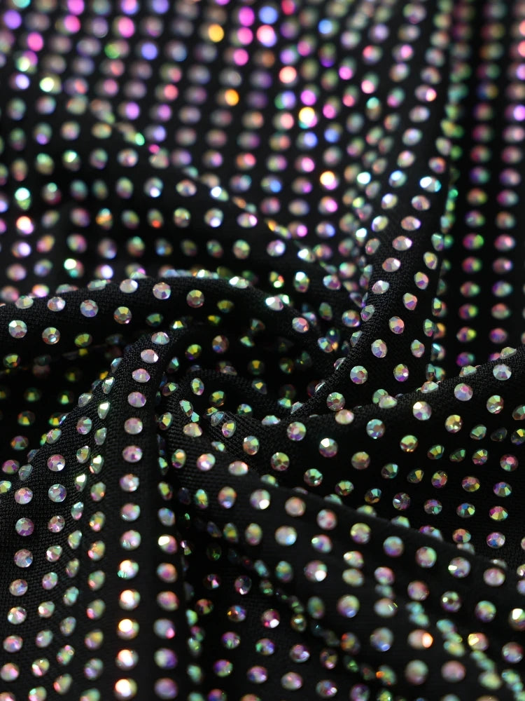 Close-up of iridescent rhinestone fabric on a black background