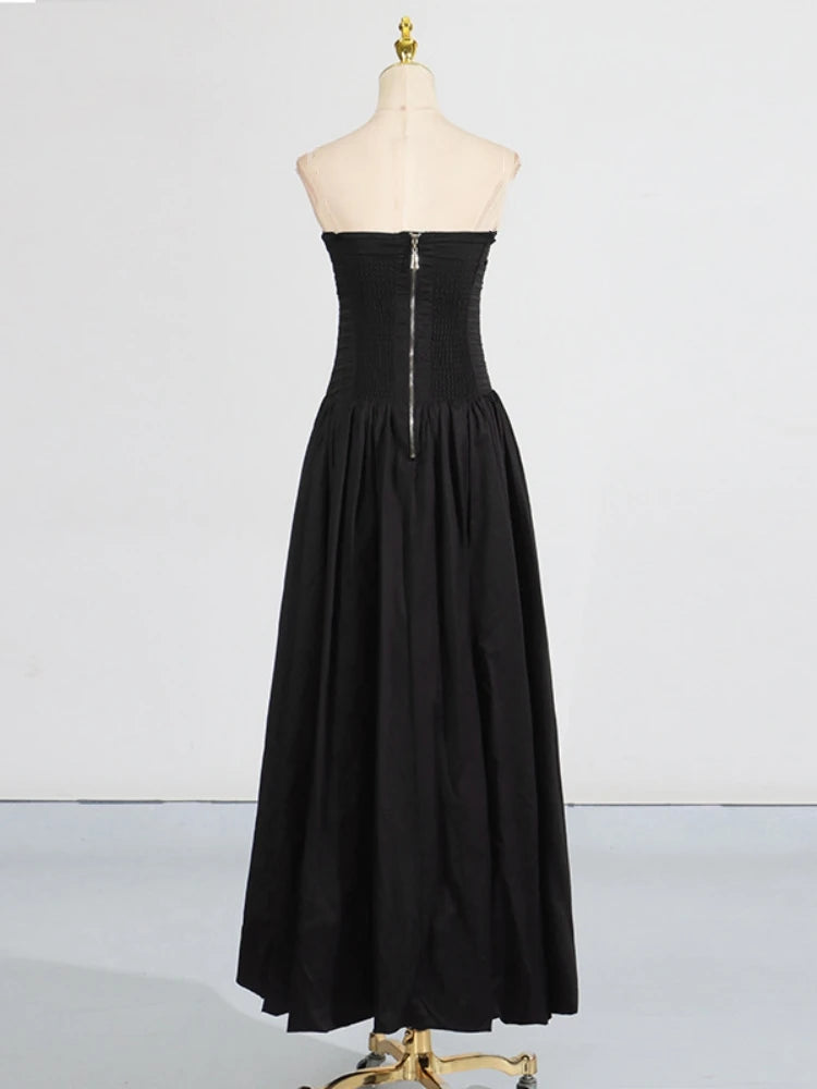Black strapless dress on a mannequin against a white background