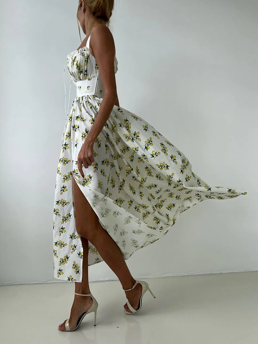 Woman wearing a white floral dress with a belt against a plain background