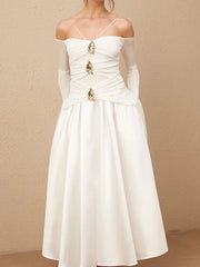White dress with gold embellishments on a beige background