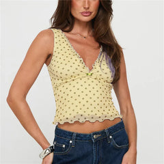 Woman wearing a yellow polka dot top and blue jeans on a white background