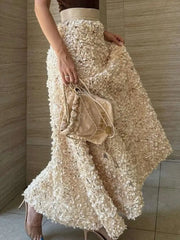 Person wearing a textured beige skirt holding a matching handbag against a neutral background