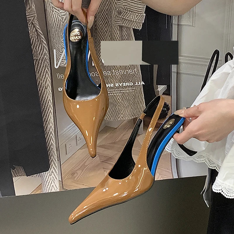 Brown heeled shoes with blue soles held by a person in a store setting.