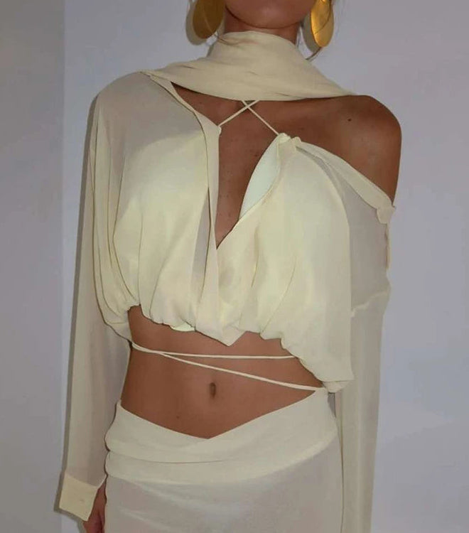White sheer top with cut-out design on a plain background