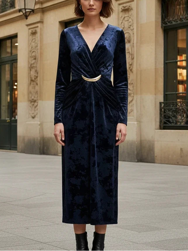 Woman in a blue velvet dress standing in an urban setting