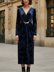 Woman in a blue velvet dress standing in an urban setting