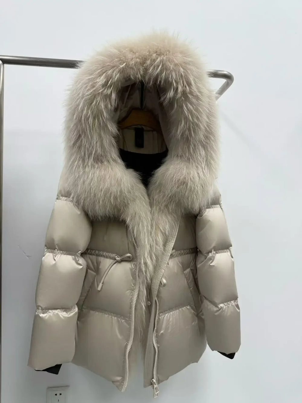 Beige puffer jacket with large fur hood on a white background