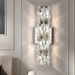 An elegant crystal wall light with a long arm and a decorative shade, adding a touch of luxury to a bedroom.