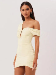 Woman wearing a light yellow one-shoulder dress on a white background