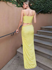 Woman wearing a yellow two-piece V-neck party set with a sleeveless crop top and a slim ankle-length skirt — a bright summer outfit perfect for carnivals or events.