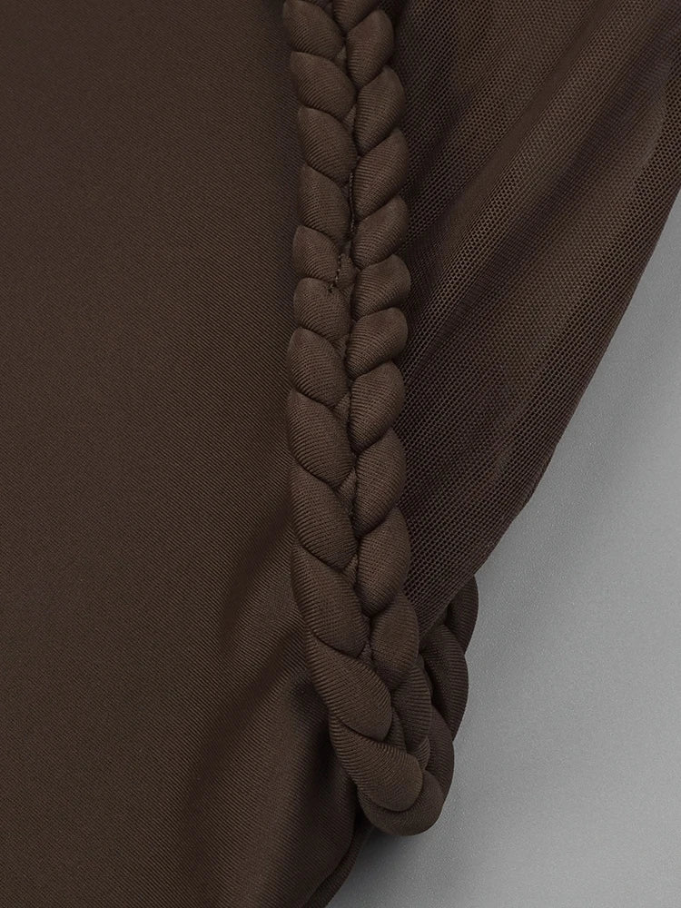 Brown fabric with a braided detail on a plain background