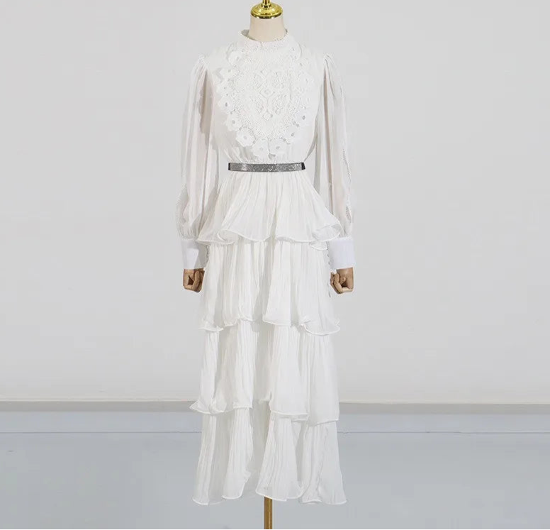 White dress with lace details on a mannequin against a plain background