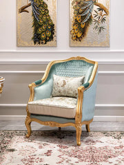 Luxurious armchair with gold accents in a room with peacock feather artworks on the wall.