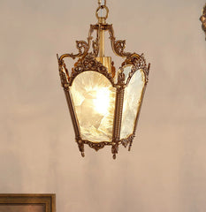 Decorative pendant light with ornate design and glass cover