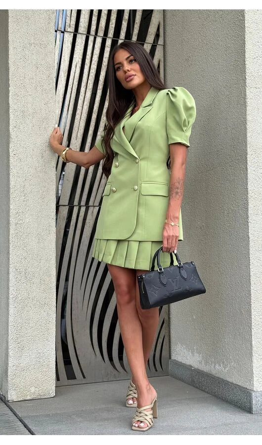 Woman in a green outfit standing against a modern architectural background