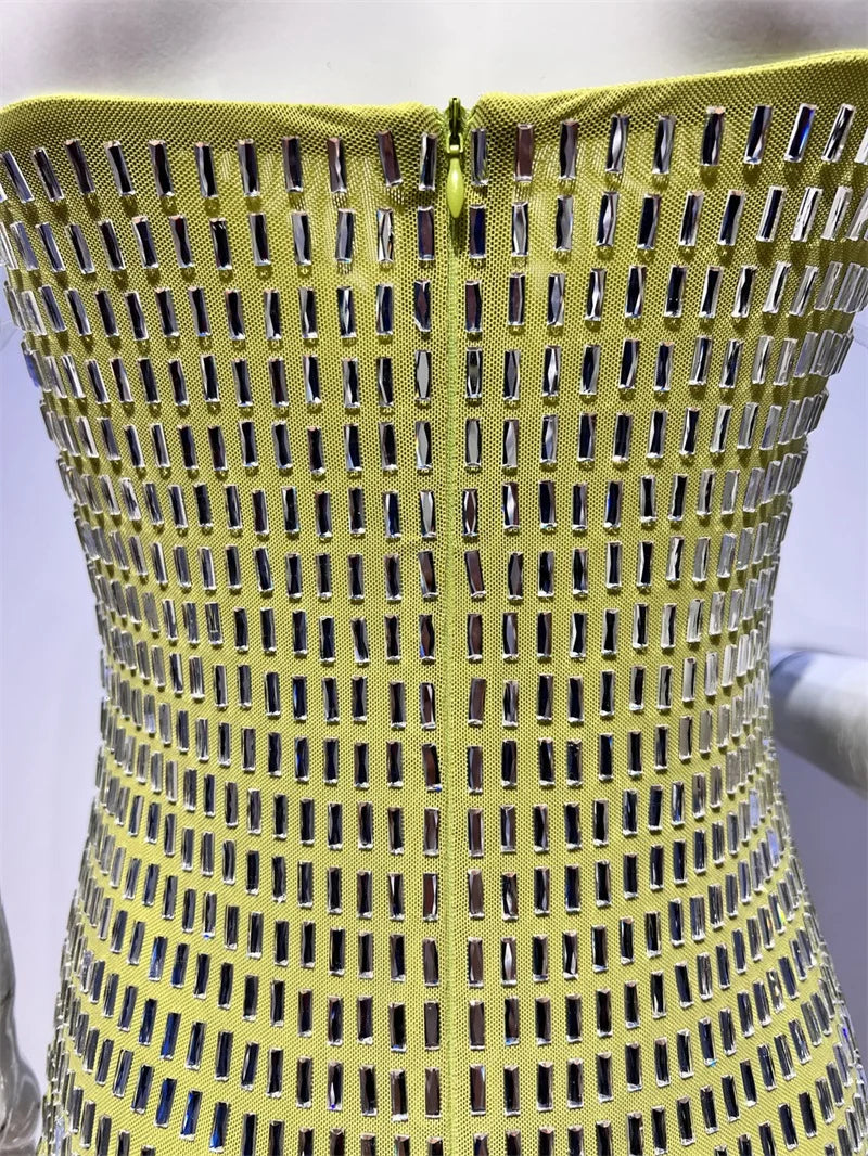 Close-up of a yellow dress with metallic embellishments on a white background