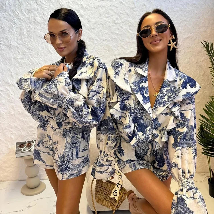 Two women wearing matching blue and white patterned outfits posing together.