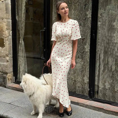 Woman wearing a polka dot midi dress with a dog