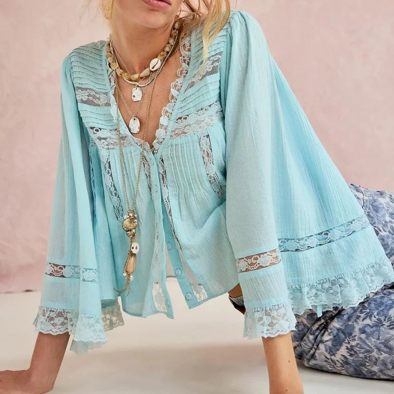 Light blue lace top worn by a person with a pink background
