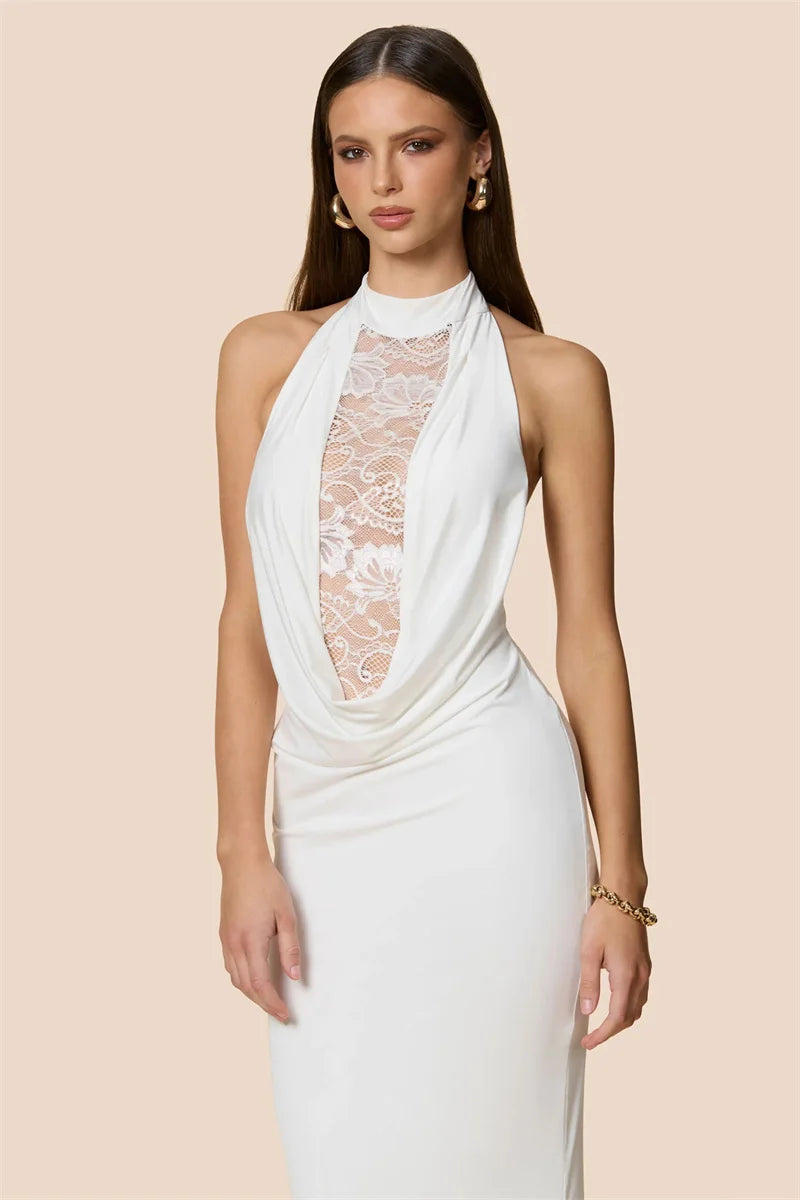 Woman wearing a white halter neck dress with lace detailing on a beige background