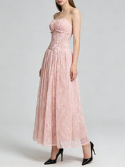 Woman wearing a pink strapless lace dress on a white background