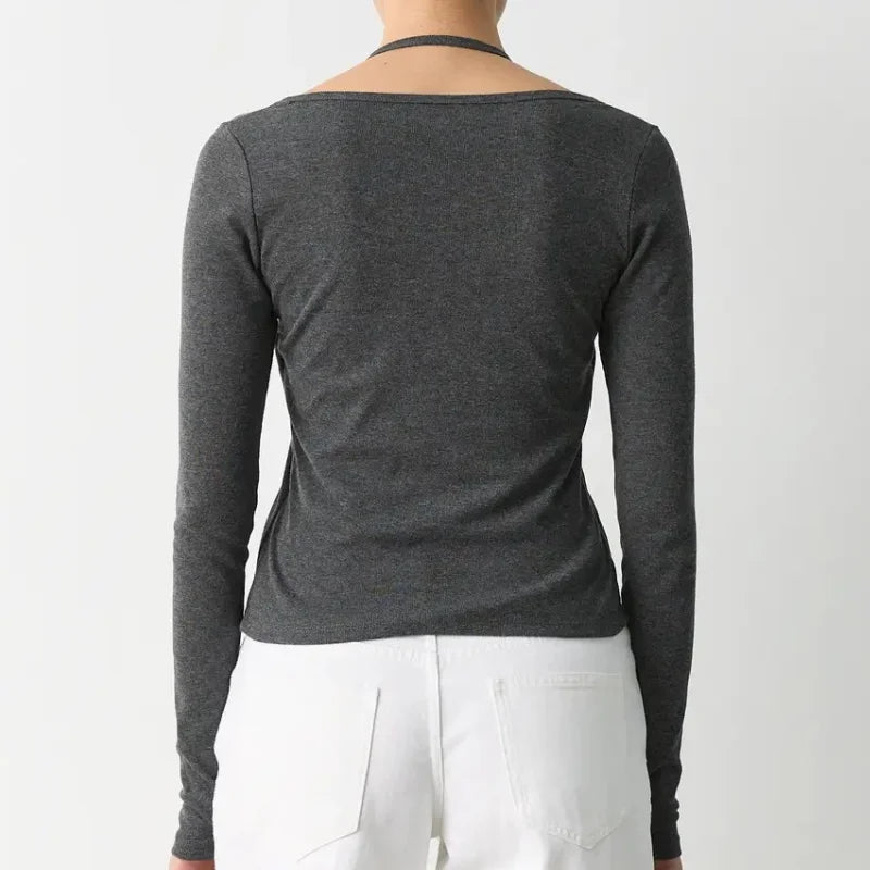 Person wearing a dark gray long-sleeve top on a white background