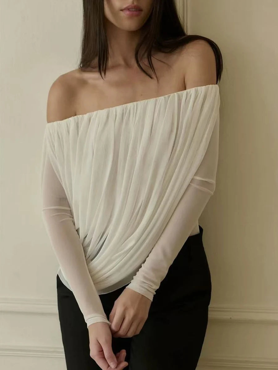 Woman wearing an off-shoulder beige top against a neutral background
