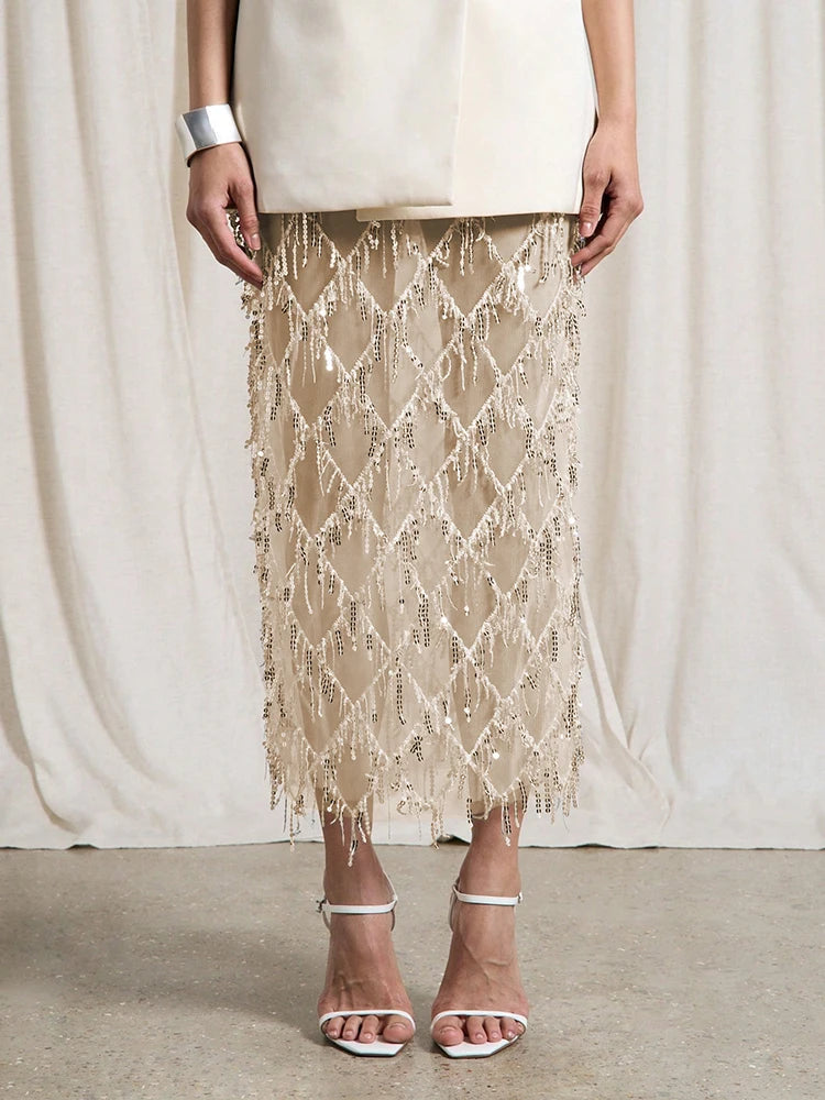 Person wearing a beige lace skirt with a plain background
