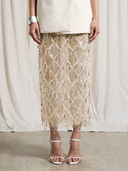 Person wearing a beige lace skirt with a plain background