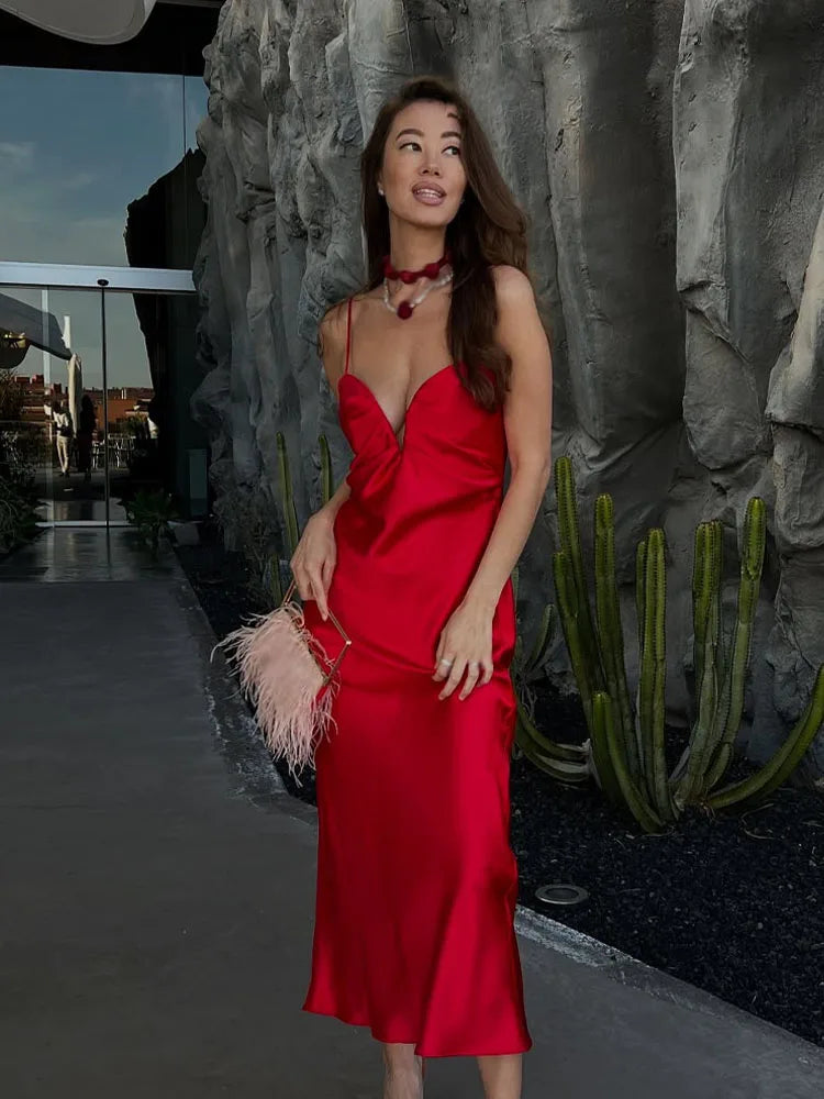 Woman in a red dress standing outdoors with a cactus plant in the background