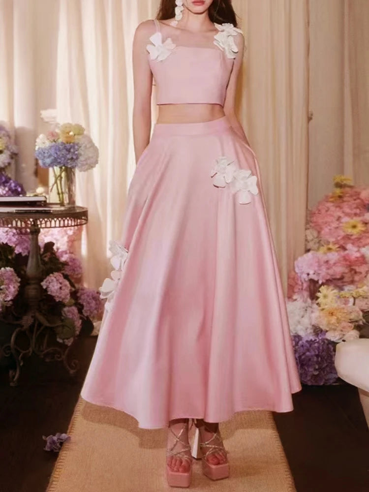 Pink two-piece outfit with floral details in a decorated indoor setting