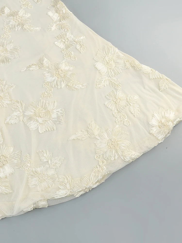 White fabric with floral embroidery on a gray background