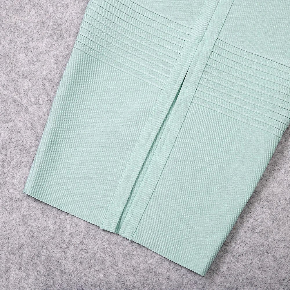 Light green fabric with pleated details on a gray surface