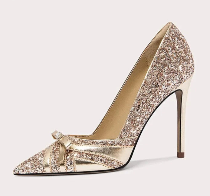 Sparkly high-heeled shoe with a bow on a white background